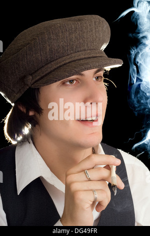 Young man holding a cigarette and looking forward. Isolated Stock Photo