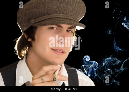 Portrait of smoking man wearing peaked cap. Isolated on black Stock Photo