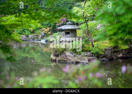 Stone lantern in a Japanese garden on a rainy day. Selective focus on the lantern. Stock Photo