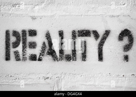 reality word with question mark handwritten on the white brick wall Stock Photo