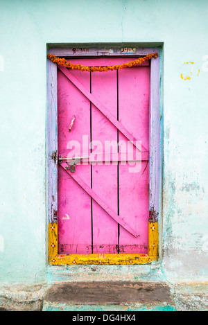 Old Wooden door painted pink in an rural indian village. Andhra Pradesh, India Stock Photo