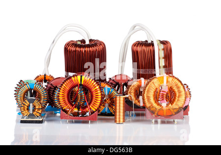 Selection of many Industrial Toroidal Choke Coils isolated and reflected on White Background Stock Photo