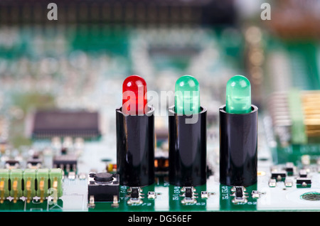 Two green and one red LED in sockets on a circuit board as Close-up view Stock Photo