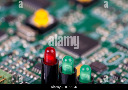 Two green and one red LED in sockets diagonally in a row on a circuit board Stock Photo