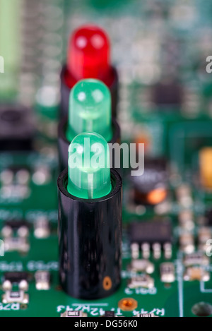 Two green and one red LED in sockets iin a row on a circuit board Stock Photo