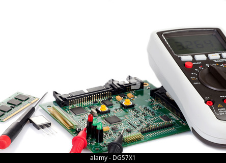 Digital multimeter is with a circuit board and electronic components and tools isolated on white background Stock Photo