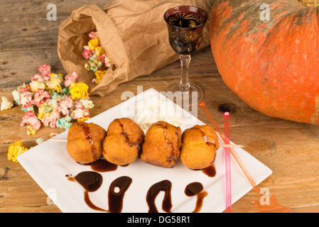 A traditional sweet Halloween dessert served with holiday decoration. Stock Photo