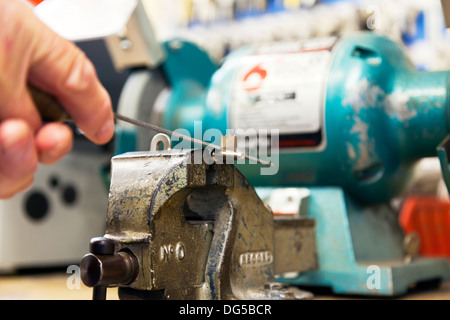 key cutter filing mortice key in vice cutting keys locksmith male mans hands Stock Photo