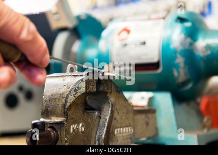 key cutter filing mortice key in vice cutting keys locksmith male mans hands Stock Photo