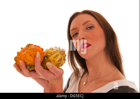 Young girl holding colorful pumpkins in her hand and looking into the camera Stock Photo