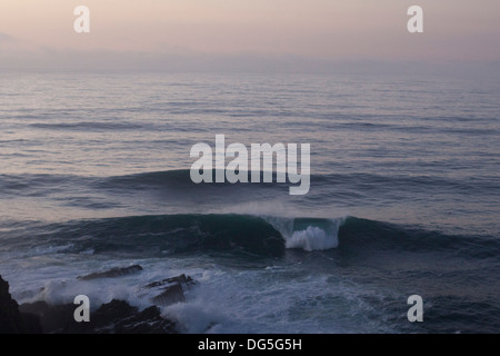 a big wave breaks on a pointbreak in the algarve in portugal Stock Photo
