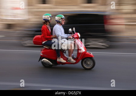 couple on a red vespa scooter moped  in rome italy Stock Photo