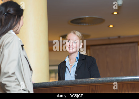 young female receptionist at hotel desk Stock Photo