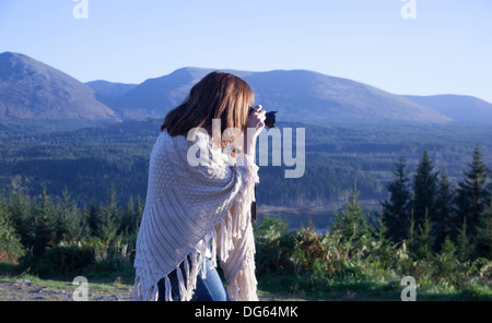 Woman taking a photograph at Invergarry Loch in the Scottish Highlands, Scotland. Stock Photo