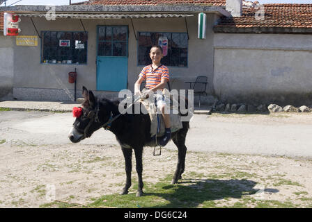 Strandja, Bulgaria. 15th Oct, 2013: Boy travels by donkey to school, shops and for just some fun play time around the village, many Bulgarian children use donkey's as a transport in rural Strandja mountain village's.  Bulgaria EAstern Europe.  Credit:  Clifford Norton / Alamy Live News Stock Photo