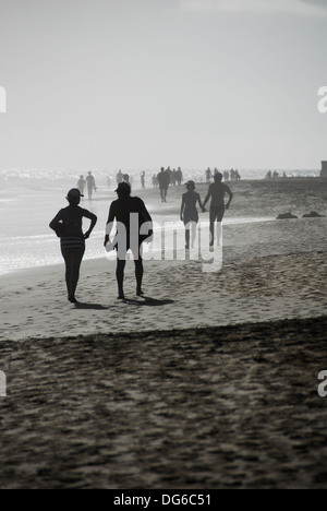 Couples walking and holding hands on beach Stock Photo