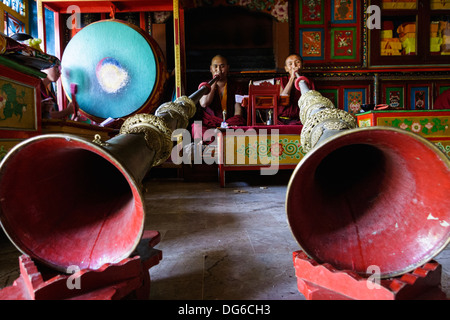 Two Tibetan monks playing horns at a lamasery in Bodhnath, Kathmandu, Nepal Stock Photo