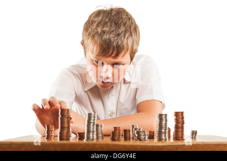 A young boy of 10 counts his money and stacks it up Stock Photo