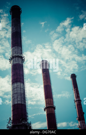 Dramatic sky and three industrial chimneys from an electric power plant in Gdansk, Poland Stock Photo