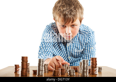 A young boy of 10 counts his money and stacks it up Stock Photo