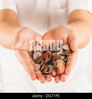 Hands full of loose change in English currency Stock Photo