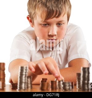 A young boy of 10 counts his money and stacks it up Stock Photo