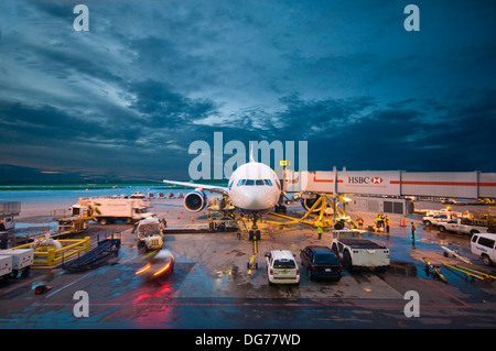 An aeroplane awaits departure from an airport at dusk Stock Photo