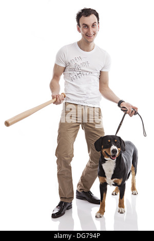 Young Caucasian man holding bat, with Entlebucher Sennenhund dog Stock Photo