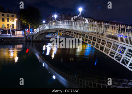 Dublin, Ireland - October 14, 2013: The Ha'penny Bridge on a dark night over the River Liffey in the centre of Dublin. Stock Photo