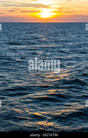 Reflections of the sun on the water at dusk Stock Photo