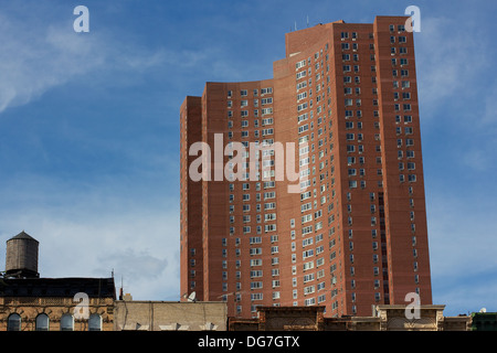 Confucius Plaza apartment tower towering over the roofs of old tenement buildings in Chinatown Manhattan, New York, NY, USA. Stock Photo