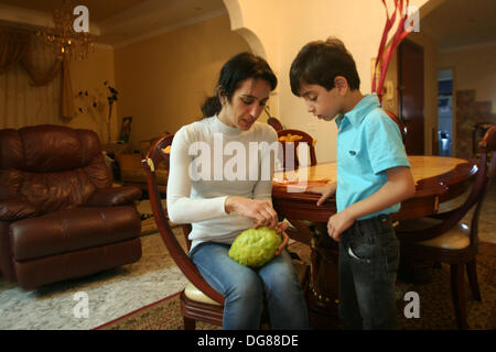 Nablus, West Bank, Palestinian Territory, . 16th Oct, 2013. A woman and her son from the ancient Samaritan community decorate a Sukkah made from fresh fruit for the holiday of the Tabernacle's, or Sukkot, in Mount Gerizim near the West Bank town of Nablus, Wenesday, Oct. 16, 2013. The Sukkah is a temporary structure built for the Jewish holiday Sukkot, which the Samaritans will celebrate early . According to tradition, the Samaritans are descendant's of Jews who were not deported when the Assyrians conquered Israel in the 8th century B.C. and of the small community of around 700 people, h Stock Photo