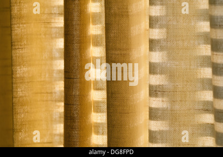 Shadows and textures on earth yellow colored curtains Stock Photo