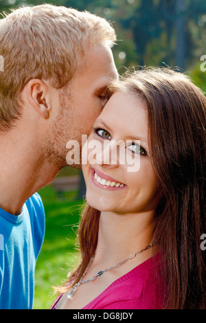 girl is whispering in ear of boyfriend isolated on white background