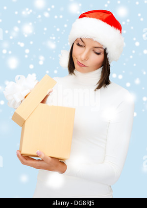 suspicious woman in santa helper hat with gift box Stock Photo