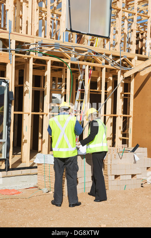 civil engineer and worker discussing issues at the construction site Stock Photo