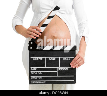 Pregnant woman hands holding clapper board on her belly Stock Photo