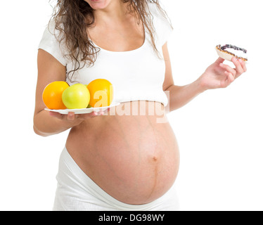 pregnant woman choosing between healthy food fruits and cake isolated Stock Photo