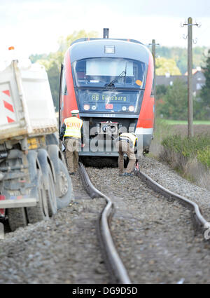 Mindelheim, Germany. 17th Oct, 2013. Policemen secure a railway crossing after an accident near Mindelheim, Germany, 17 October 2013. According to the police, the driver of a gravel truck overlooked the regional train at an unguarded railroad crossing. The truck was hit by the train and dragged. By the force of the impact the train derailed and damaged the tracks. Photo: STEFAN PUCHNER/dpa/Alamy Live News Stock Photo
