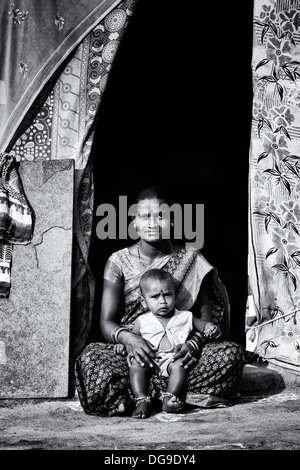 Lower caste Indian baby sitting outside her bender / tent / shelter ...