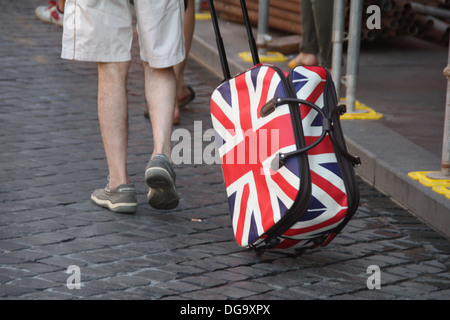 man with union jack flag trolley case bag in rome italy Stock Photo