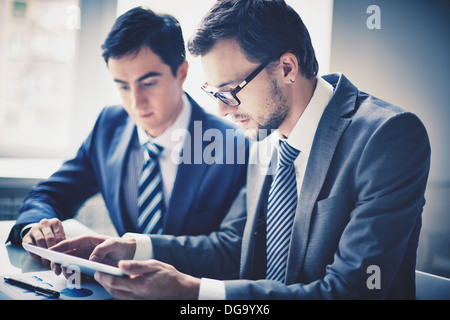Image of two young businessmen using touchpad Stock Photo