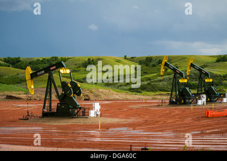 Oil pumpers in the Bakken play shale oil fields in the rolling hills near Williston, North Dakota, USA. Stock Photo