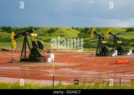 Oil pumpers in the Bakken play shale oil fields in the rolling hills near Williston, North Dakota, USA. Stock Photo