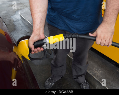 Man pumping gas at a gas station Stock Photo