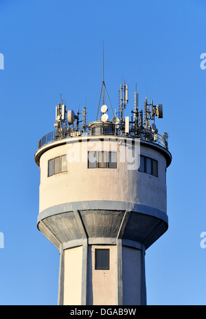 Various antennas on the roof of an old water tower on blue sky Stock Photo