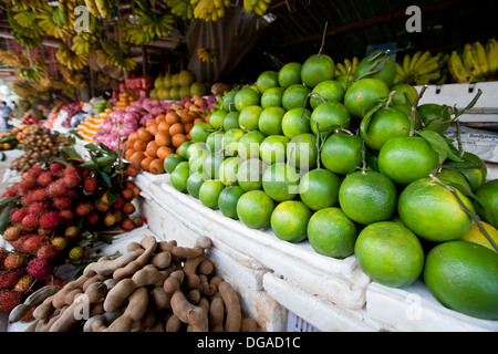 A local street produce market filled selling fruits, including limes, ramboutan, tamarind in Siem Reap, Cambodia Stock Photo