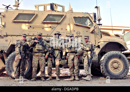 U.S. Soldiers stand in front of a mine-resistant, ambush-protected vehicle at the New Kabul Compound September 26, 2013 in Kabul province, Afghanistan. Stock Photo