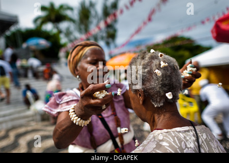 A Baiana woman performs the Afro-Brazilian spiritual cleansing ritual, in front of the St. Lazarus church in Salvador, Brazil. Stock Photo