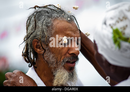 A Baiana woman performs the Afro-Brazilian spiritual cleansing ritual in front of the St. Lazarus church in Salvador, Brazil. Stock Photo